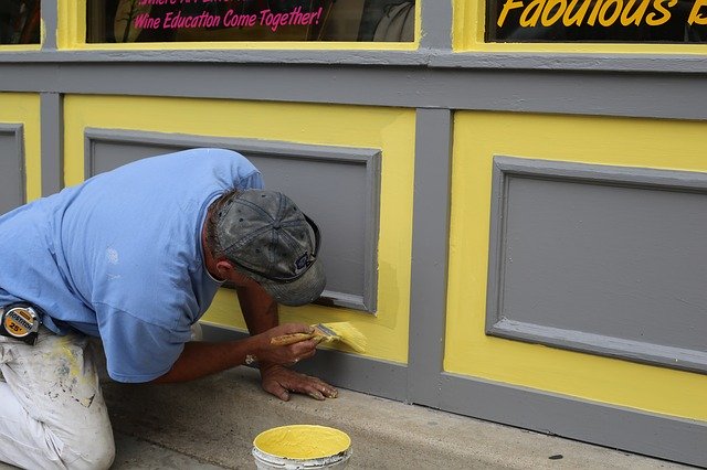 malíř pracující na fasádě domu